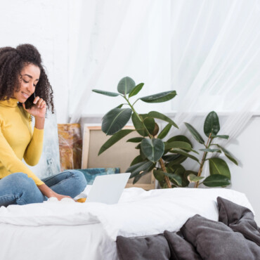 Employee at home sitting on a bed